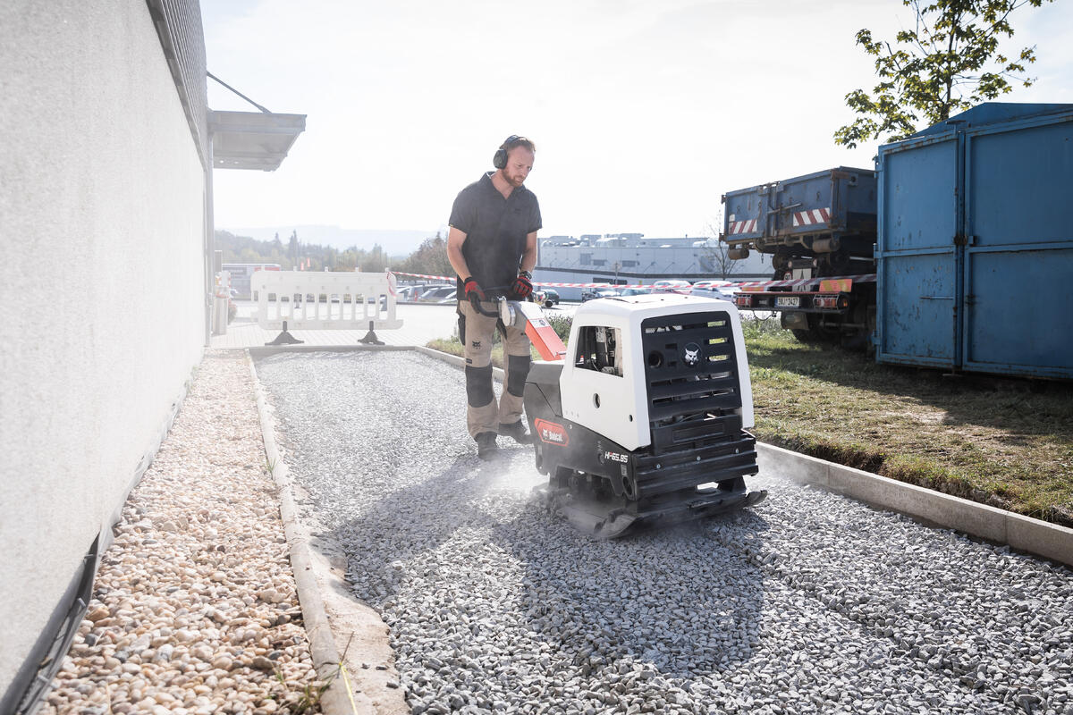 Leichte Bodenverdichtung auf Schottersteinen mit einer Rüttelplatte