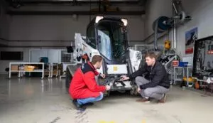 Bobcat-Techniker untersuchen einen Bagger