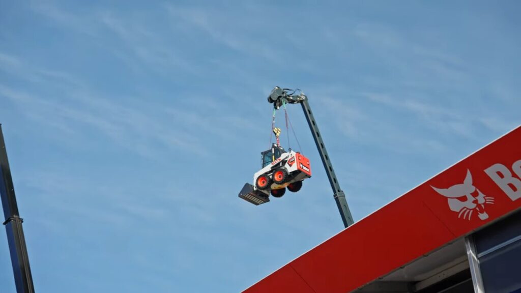 Ein Bobcat-Lader der mit einem Teleskoplader über den Bobcat-Stand auf der BAUMA gehoben wurde