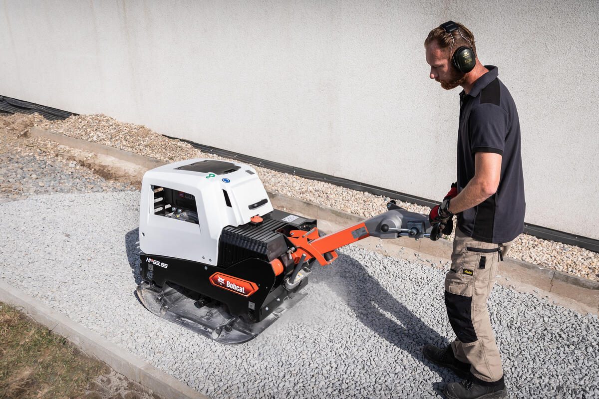 Arbeiter mit einer Rüttelplatte von Bobcat