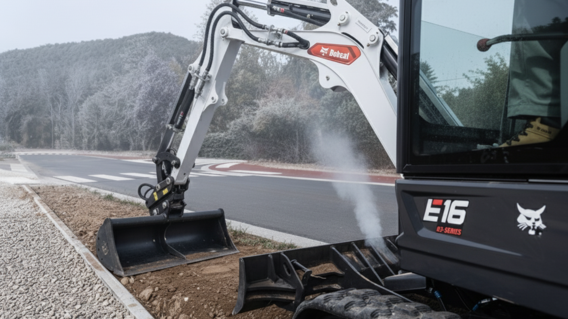 E16 Bagger vor winterlicher Baustelle im Leerlauf.